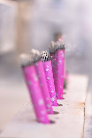 Rose color incense sticks planted and lit in a Japanese temple.の写真素材