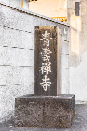 Name of Seiunzenji zen temple engraved in Japanese ideograms on a rectangular block of stone at the entrance of one of the seven Yanaka Happiness Temple in Tokyo.のeditorial素材