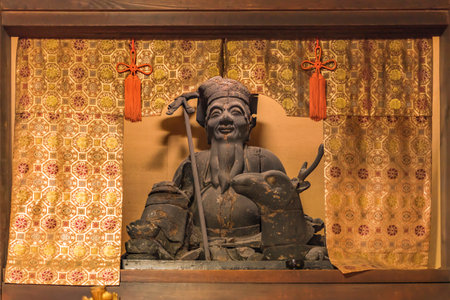 Wooden statue of Shinto deity Juronin, incarnation of the Antarctic star and symbolizing longevity, which is represented here with a deer behind a curtain of gold thread at Zen Choanji temple in Tokyo.のeditorial素材