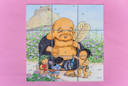 Pink wall of Tokyo Shushoin temple decorated with cute illustrations on tiling of the Buddhist deity Hoteison symbol of generosity which is one of the seven gods of happiness.のeditorial素材