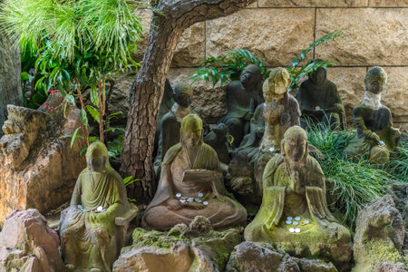 Stone statues of the sixteen arhats of Zen Buddhism with commemorative plates Itahi adorned with a Sanskrit sign in the Choanji temple in Tokyo.のeditorial素材