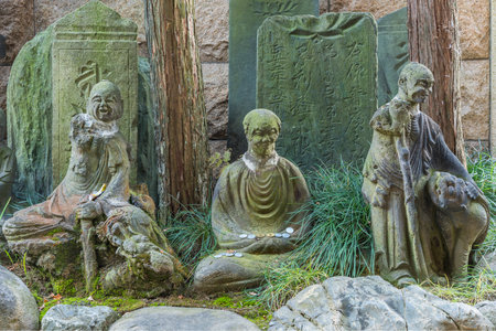 Stone statues of the sixteen arhats of Zen Buddhism with commemorative plates Itahi adorned with a Sanskrit sign in the Choanji temple in Tokyo.のeditorial素材