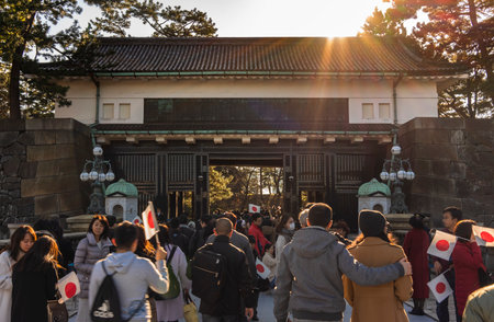 Tokyo, Japan - January 02 2020: People holding Japanese flags on their way to the appearance on the occasion of the New Year of Their Majesties the Emperor and Empress of Japan in the Imperial Palace in Tokyo.のeditorial素材