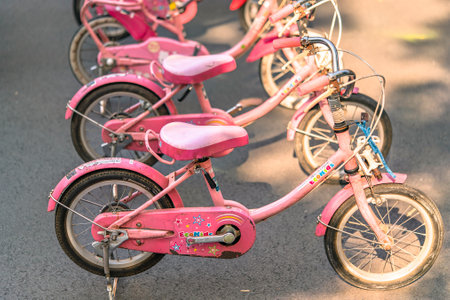 tokyo, japan - november 17 2019: Pink training bikes for children parked in row on parking decorated with stickers of cute stars and the word Eco Kids.のeditorial素材
