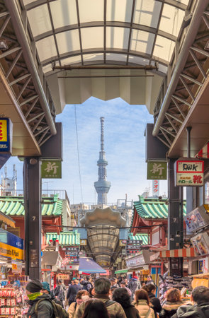 tokyo, japan - january 28 2020: Tourists walking in the nearby Shin-Nakamise covered arcade shopping streets of Sensoji temple in Asakusa with Tokyo Skytree tower in background.のeditorial素材