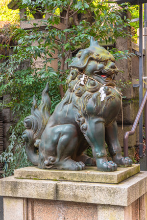 tokyo, japan - march 05 2020: Bronze statue of a lion komainu mythological guardian with shimenawa rope on neck in the Japanese Atago shrine of Tokyo.のeditorial素材