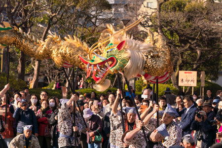 tokyo, japan - march 18 2020: Japanese puppet masters holding a huge golden dragon for the traditional dance festival dedicated to the bodhisattva Kannon in the Sensoji temple of Asakusa.のeditorial素材