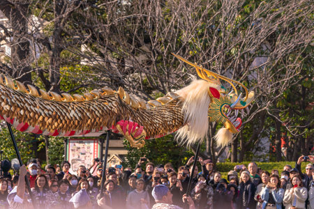 tokyo, japan - march 18 2020: Japanese puppet masters holding a huge golden dragon for the traditional dance festival dedicated to the bodhisattva Kannon in the Sensoji temple of Asakusa.のeditorial素材