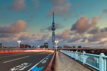 Cars headlights on the Kototoi Bridge of the Sumida River leading to the Tokyo Skytree Tower at sunset.のeditorial素材