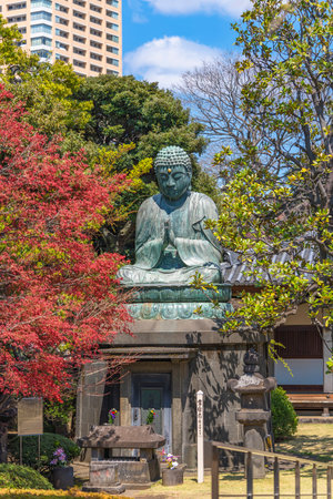 tokyo,japan - march 31 2020: Bronze statue of Buddha Shaka Nyorai with a stone lantern and the sentence May Peace Prevail On Earth on a Peace Pole Project's pole in the Tennoji temple of Yanaka.のeditorial素材