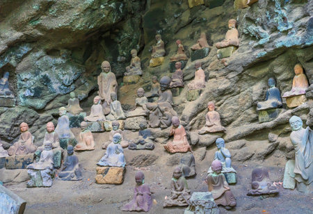 chiba, japan - july 18 2020: Buddhist statues of arhat monks created by Jingoro Eirei Ono in the cavity of Gomakutsu or fiery cave carved like the flames of the homa ritual in Mount Nokogiri quarry.のeditorial素材
