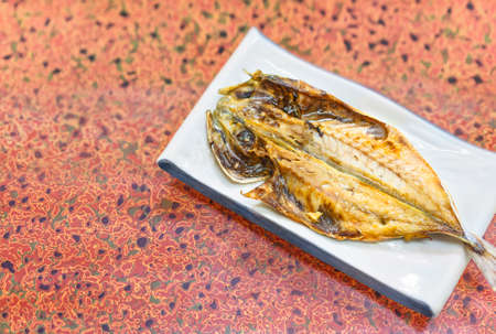 Japanese traditional grilled fish on a flower hemp leaf silver pattern table cloth.の写真素材