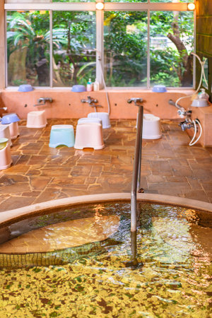 chiba, japan - july 18 2020: Traditional Japanese indoor onsen hot spring with furo-isu plastic bath chairs, shower taps or faucets and karan buckets for washing the body before bath known as kakeyu.のeditorial素材