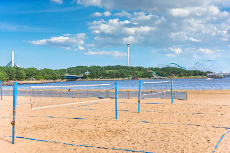 yokohama, japan - july 19 2020: Sand court of Beach volleyball divided by a net at Uminokoen city park with a seascape of the amusement park of Yokohama Hakkeijima Sea Paradise in backgroundのeditorial素材
