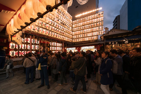 asakusa, japan - november 08 2019: People line up to enter the Ootori shrine decorated at night with luminous paper lanterns to buy auspicious rakes at Tori-no-Ichi Fair to have success in business.のeditorial素材