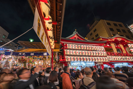 asakusa, japan - november 08 2019: Wide view of the Tori-no-Ichi Fair in Ootori shrine where the crowd which stand in line for make a wish is surrounded by luminous paper lanterns and auspicious rakesのeditorial素材