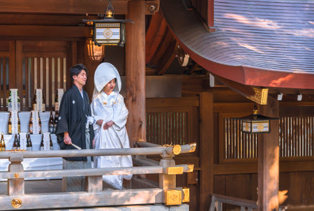 tokyo, japan - october 10 2020: Traditional Japanese shinto wedding of a couple in black haori kimono and white shiromuku under a lantern ornated of the imperial coat of arm in the Meiji Shrine.のeditorial素材