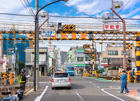 tokyo, japan - october 11 2020: Cars traffic passing over a level crossing in the local shopping district of Kanegafuchi street adjacent to the Kanegafuchi station in the Sumida ward of Tokyo.のeditorial素材