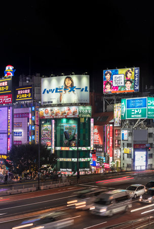 tokyo, japan - november 05 2019: Night view of the cars traffic on the koshu kaido route of Shinjuku along catchy advertising signs and placards of the skyscrapers and buildings of the Rambling Road.のeditorial素材