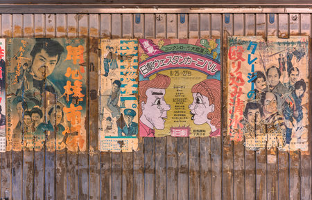 Torn old vintage japanese posters of samurai retro movies and rock and roll music concert stuck on the rusted wall of Yuraku Concourse underpass at Yurakucho station.のeditorial素材