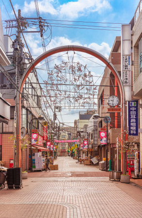 tokyo, japan - april 07 2019: Metallic arch gate adorned with cherry blossoms decorations and paper lanterns during spring at the enter of the Somei-Ginza shopping street of Komagome in Toshima ward.のeditorial素材