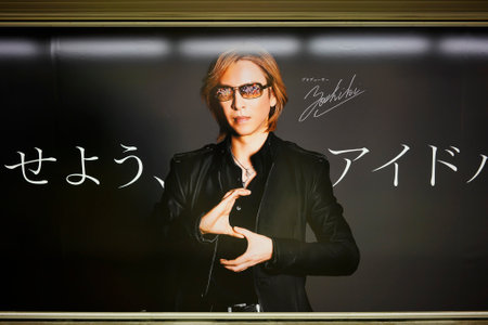 tokyo, japan - april 07 2019: Poster of Yoshiki the Japanese drummer musician of the Visual rock band X Japan producing the mobile game of anime idols THE iDOLM @ STER: SHINY COLORS on a subway wall.のeditorial素材