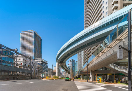 tokyo, japan - april 09 2021: Pedestrian crossing on Shiodome Avenue overlooked by the automated guideway transit of the Tokyo New Transit Waterfront Line called Yurikamome meaning black-headed gull.のeditorial素材