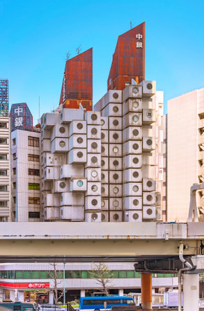 tokyo, japan - july 05 2021: Nakagin Capsule Tower building topped by a rusted corrugated sheet rooftop created in 1972 by Japanese architect Kisho Kurokawa in front of Shuto Expressway in Shimbashi.のeditorial素材