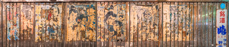 tokyo, japan - july 05 2021: Panorama of aligned japanese yakuza and samurai classic movies posters stuck along the rusted corrugated wall of Yuraku Concourse underpass between Ginza and Hibiya.のeditorial素材