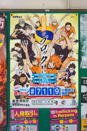 tokyo, japan - august 13 2021: Japanese poster in a train station corridor for preventing against summer heatstroke depicting characters of volleyball sport manga Haikyu !! with an emergency number.のeditorial素材