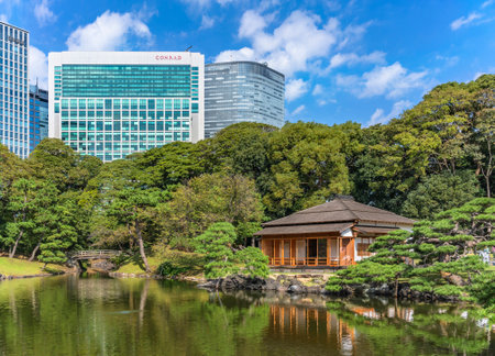 tokyo, japan - october 28 2021: Shiori-no-ike pond of Hama-rikyÅ« Gardens reflecting in the water the buildings and a traditional Japanese chashitsu tea room Tsubame-no-ochaya meaning Swallow teahouse.のeditorial素材