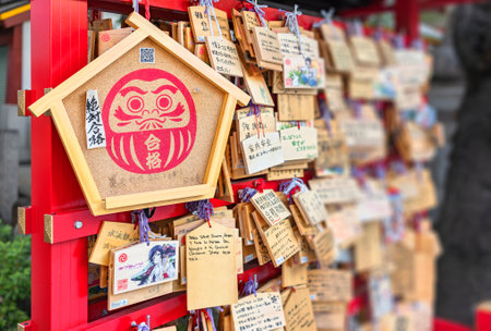 tokyo, japan - september 17 2019: Large Shinto wooden Ema plaque adorned with the Buddhist bodhidharma or daruma deity with the wishing words for success to exams in the Japanese Kanda Myojin shrine.のeditorial素材