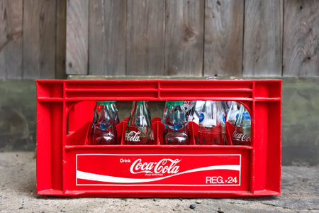 tokyo, japan - november 13 2021: Used and empty glass bottles of soda drinks like coca-cola or Japanese carbonated soft drink Ramune in a plastic mesh containers on the ground waiting for recycle.のeditorial素材
