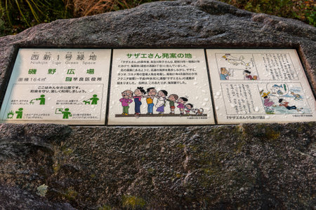 fukuoka, japan - april 20 2022: Ceramic tiles on a rock depicting illustrations and texts about the birth of the popular manga Sazae-san since 1946 by Machiko Hasegawa in the Sazaesan Street of Kyushuのeditorial素材