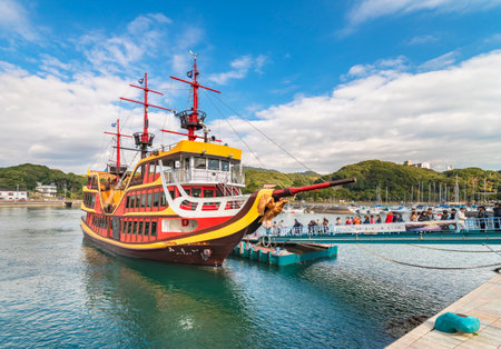 kyushu, japan - december 09 2021: Tourists boarding on the first japanese electric propulsion cruising boat called the Pirate Boat Mirai moored at the pier of the Kujukushima Pearl Sea Resort.のeditorial素材
