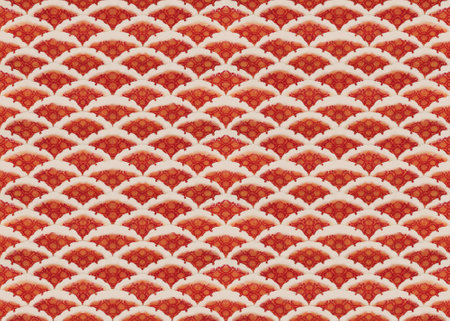 Traditional Japanese handwritten red Camellia japonica flowers called tsubaki enclosed in geometrical pattern depicting scales of brocaded carp koi or nishikoi fish symbol of luck and perseverance.の写真素材