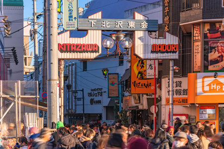 tokyo, setagaya - january 28 2023: Main gate of the Azuma Dori shopping street meaning East Street in the district of Shimokitazawa with crowds of people strolling during the tengu parade festival.のeditorial素材