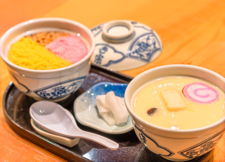 nagasaki, kyushu - dec 11 2022: Traditional Japanese egg custard Chawanmushi cuisine with pink sakura denbu, kinshi tamago shredded egg crepe and buta soboro ground pork at famous restaurant Yossou.のeditorial素材