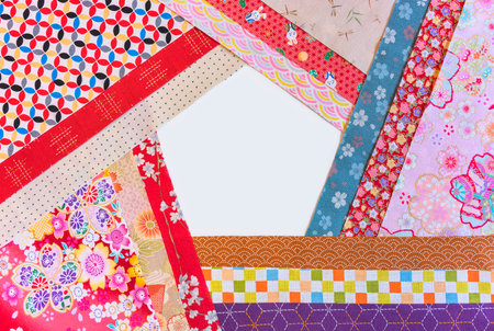 Furoshiki cloths arranged in a pentagonal formation featuring classic Japanese designs such as geometric shapes, floral motifs, and depictions of animals and insects, all set against a white backdrop.の写真素材