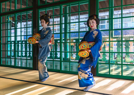 nagasaki, kyushu - dec 14 2022: Free event featuring two Japanese middle age women wearing kimono and holding furi-dutsumi tambourines in the First Ship Captains Quarters of Dejima island.のeditorial素材