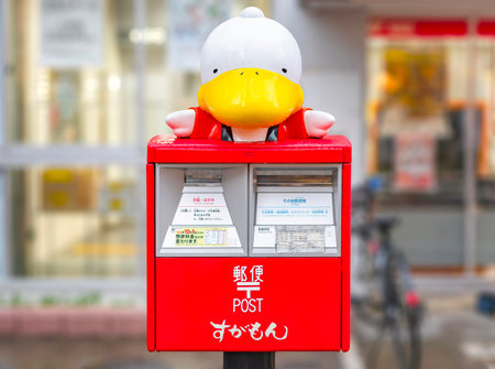 tokyo, japan - oct 14 2022: Japanese red post box decorated with a bust of a duck wearing a happi coats which is the mascot called sugamon dedicated to the city of Sugamo meaning literally duck nest.のeditorial素材