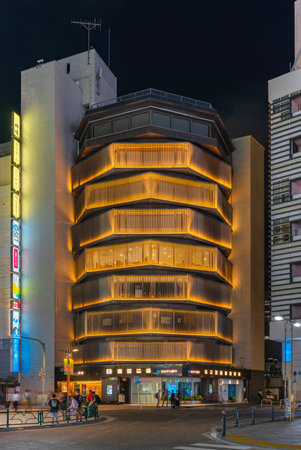 tokyo, japan - aug 7 2023: The Yasuyo building created in Shinjuku by japanese architects Shindo Akashi and Yoshiro Taniguchi in 70's with an eye-catching design of illuminated stacked bolts at night.のeditorial素材
