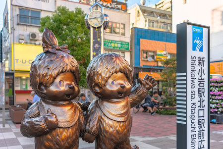 tokyo, japan - sep 12 2023: Two bronze statues of the world widely famous Japanese stuffed twin monkey toys known also as Kiki wearing a baby bib waving hello at the north exit of Shinkoiwa station.のeditorial素材