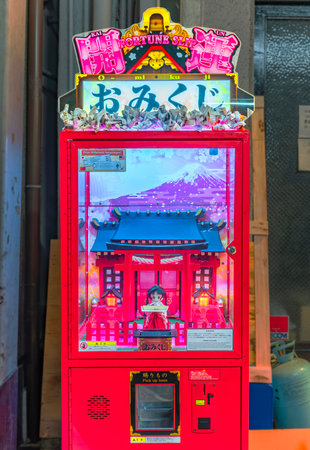 osaka, japan - dec 04 2022: An 0-mikuji horoscope or fortune slip vending machine animated with a Miko or Shrine Maiden puppet in front of a Japanese shinto shrine with the mount Fuji in background.のeditorial素材