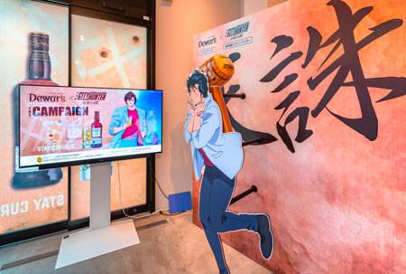 tokyo, japan - aug 9 2023: Collaboration campaign event between the Japanese anime City Hunter and the Dewar's whiskey on an advertising screen aside a life-size standee of Saeba Ryo aka Nicky Larson.のeditorial素材