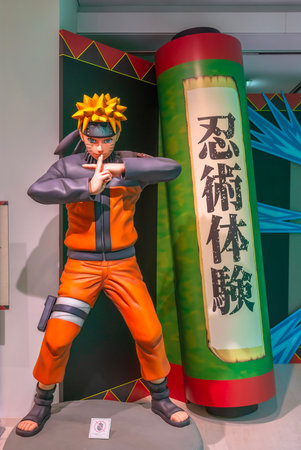 ikebukuro, japan - jan 16 2024: Life sized manga figurine of the ninja Naruto doing a jutsu attack aside a scroll written 'Experience Ninja Martial Art' at the free exhibition of Anime Tokyo Station.のeditorial素材