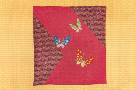Texture photography of a Japanese square-shaped zabuton cushion decorated with embroidered patterns...