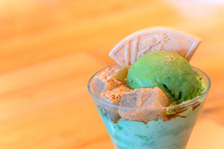A traditional Japanese dessert matcha ice cream parfait with cubes of agar jelly sprinkled with...