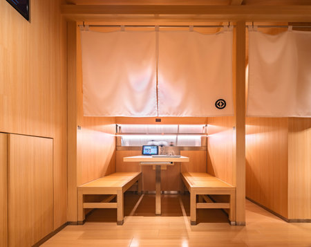 tokyo, ginza - may 14 2024: Kura Revolving Sushi Bar's modern wooden booths equipped with a digital menu displayed on a tablet and decorated in a Japanese style with traditional noren curtains.のeditorial素材