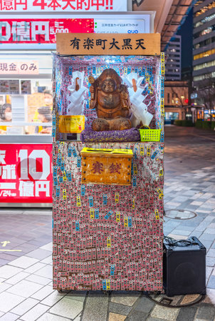 tokyo, japan - nov 29 2023: Donation box dedicated to one of the Seven Lucky Gods Daikokuten covered by votive slips named senjafuda in front of the Japan National Lottery shop of Yurakucho Station.のeditorial素材